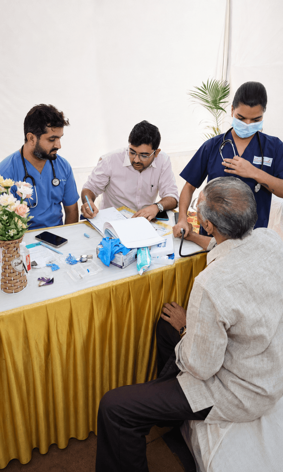 चिकित्सा शिविर में एक बुज़ुर्ग की जाँच करते स्वास्थ्यकर्मी
