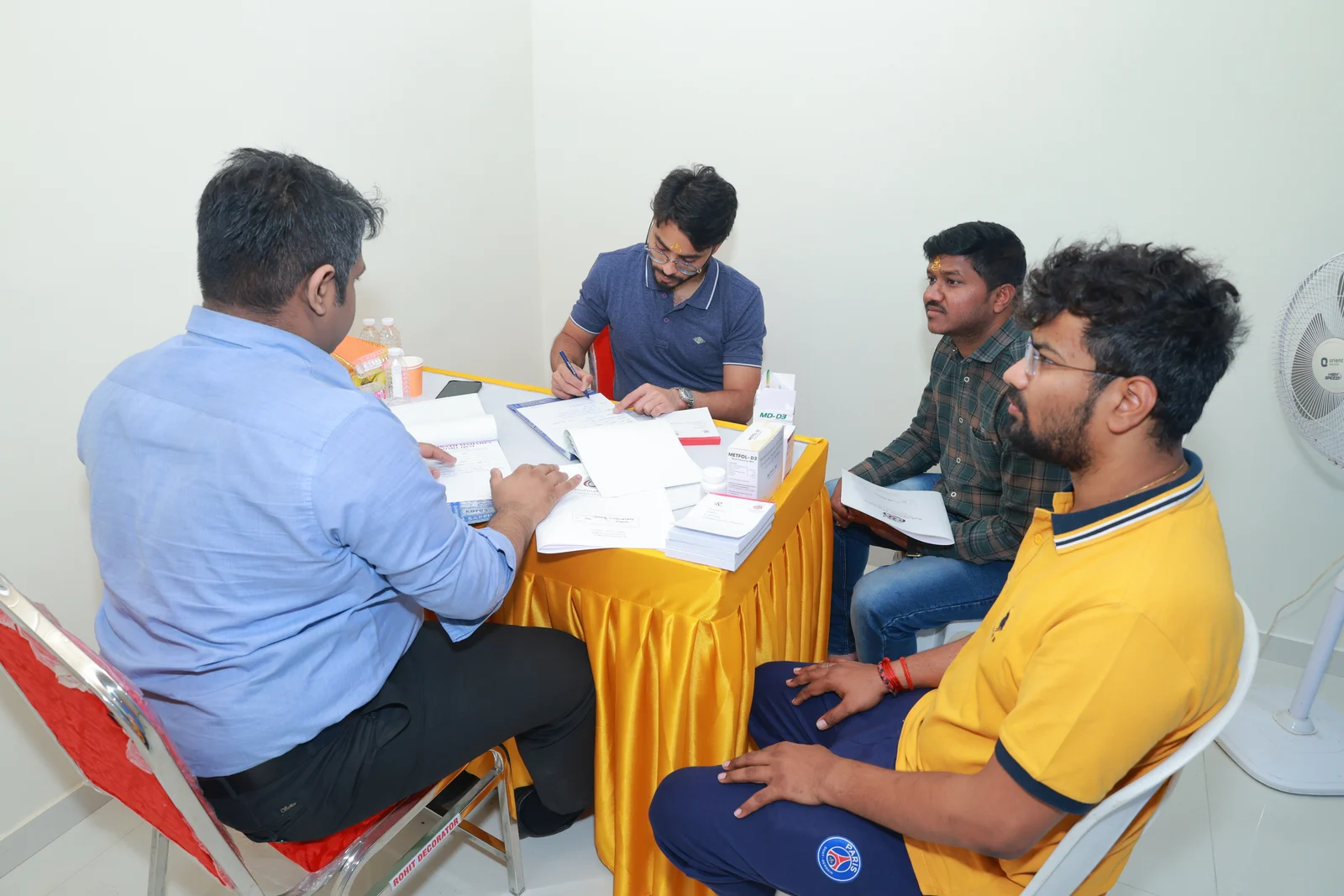 Medical camp team members and visitors gathered around a consultation table