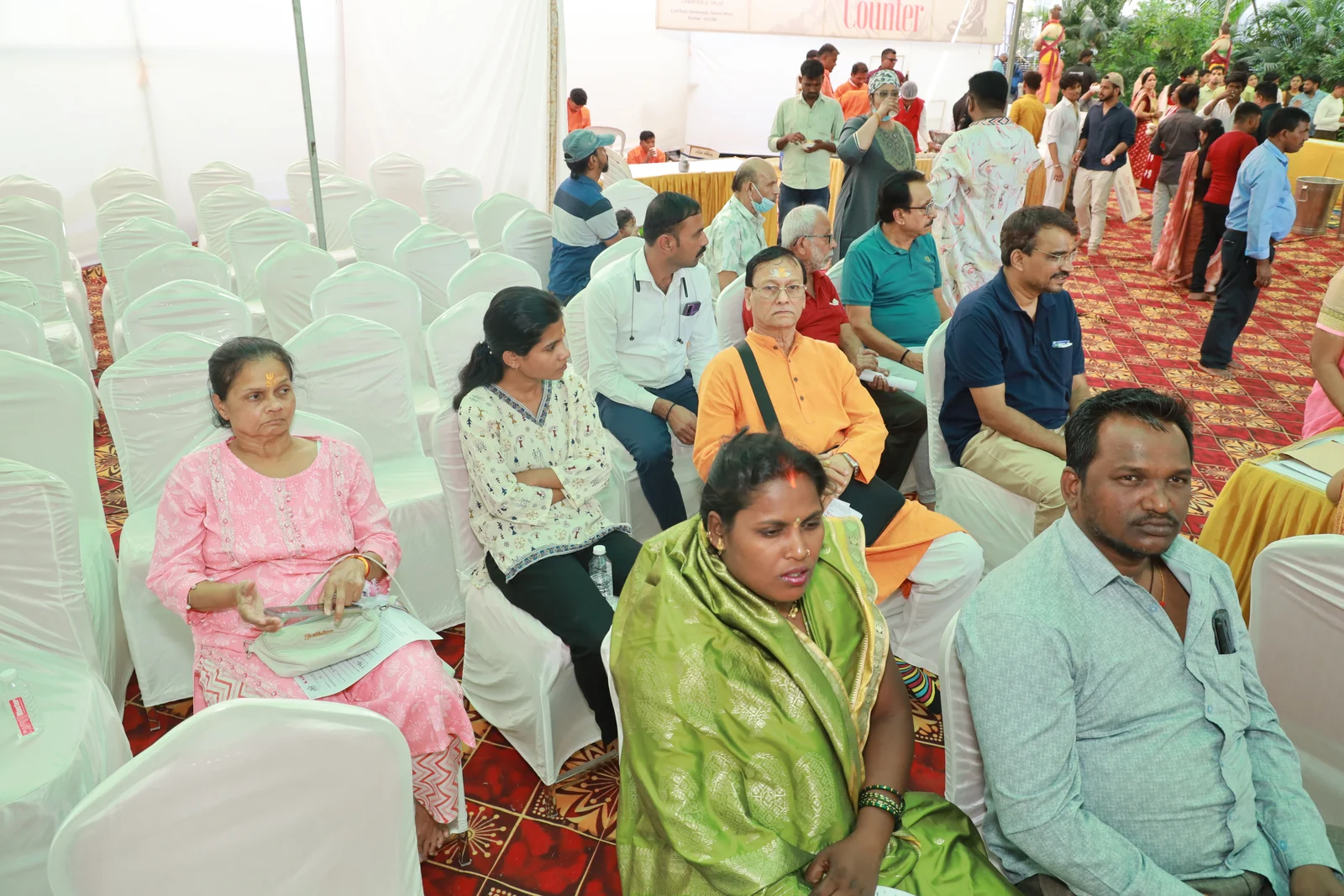Women and men seated together in the waiting area of the February 2025 medical camp